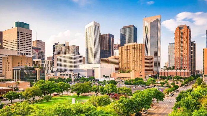 a city skyline with tall buildings and green grass at The  Studios At Channelview