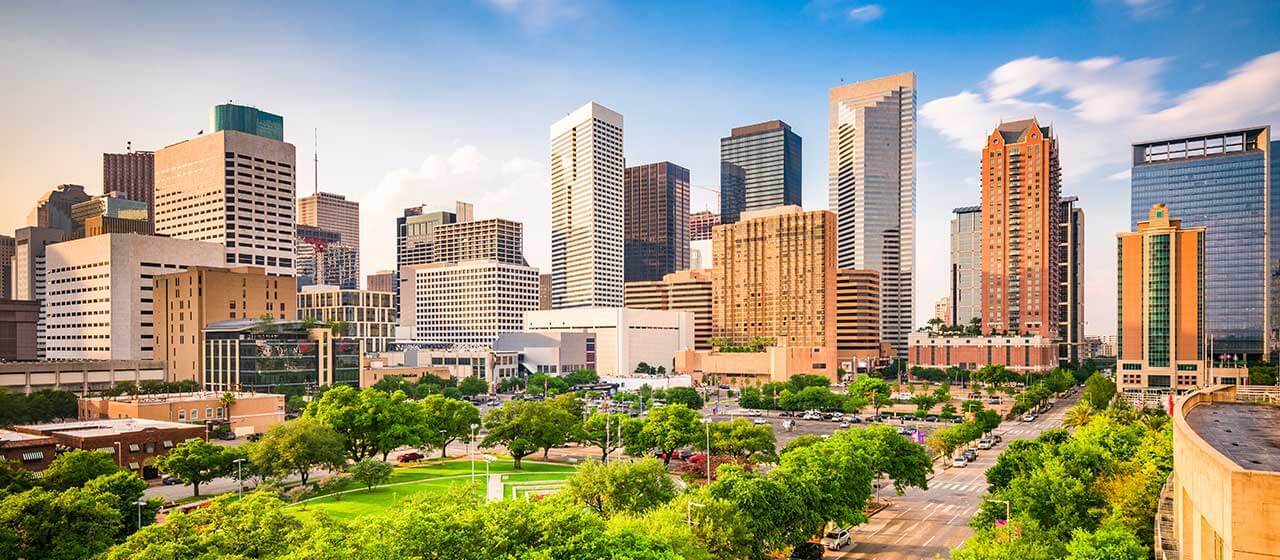 a city skyline with tall buildings and green grass at The  Studios At Channelview