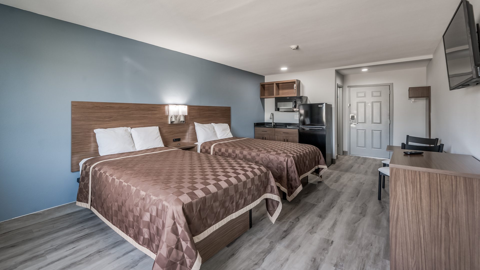 a motel room with two beds and a television at The  Studios At Channelview